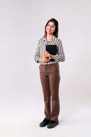 Full body portrait of a beautiful young businesswoman standing on gray backgroundの写真素材