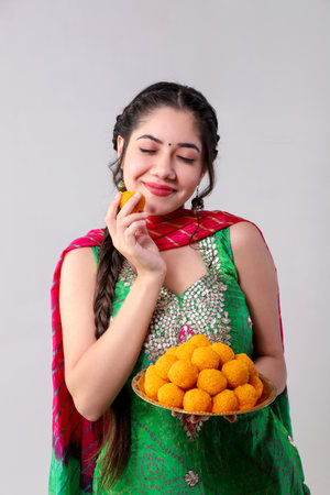 Indian woman in saree holding plate with foodの写真素材