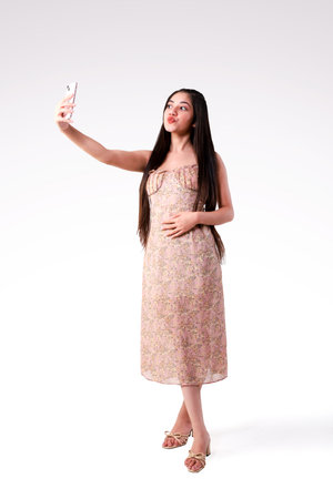 Full length portrait of a beautiful asian woman taking selfie with mobile phoneの写真素材