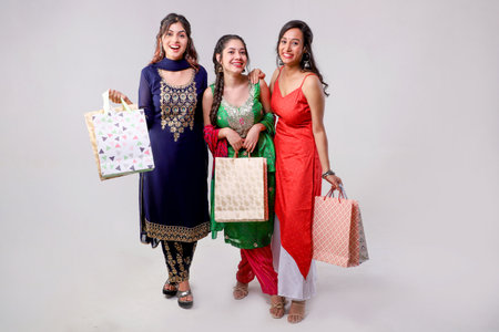 Group of young indian women holding shopping bags and smiling at cameraの写真素材