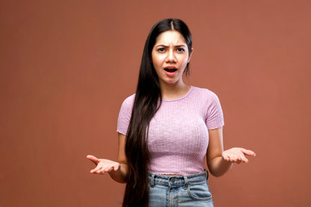 Portrait of a young asian woman on brown background. Human emotionsの写真素材