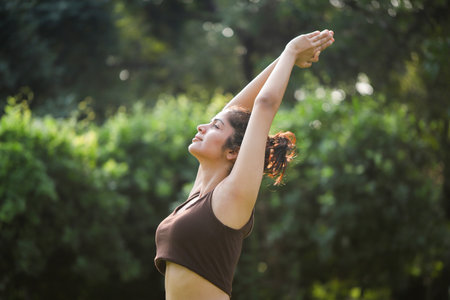 Portrait of young woman doing yoga in the park on a sunny dayの写真素材