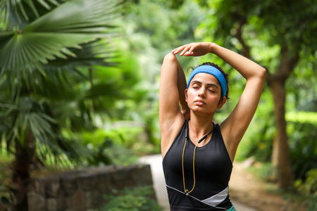 Portrait of a young woman stretching before jogging in the parkの写真素材