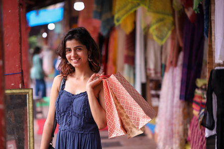 Portrait of a beautiful young woman holding shopping bags at the marketの写真素材