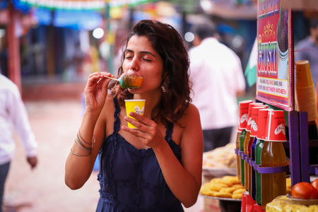 Young woman eating at a local street food market.の写真素材