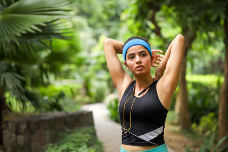 Portrait of beautiful young woman stretching before jogging in the parkの写真素材