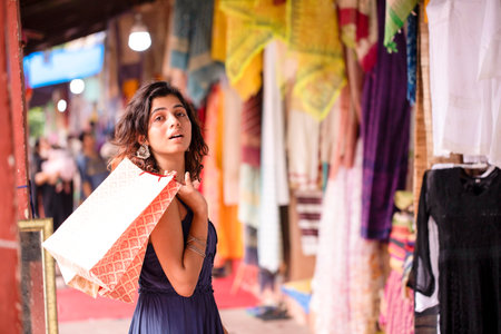 Beautiful young woman with shopping bags at the market in India.の写真素材