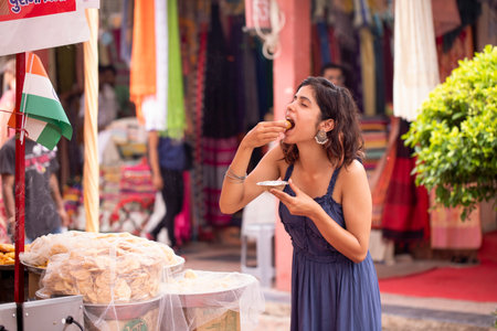 Young woman eating at a street food market in Bangkok, Thailandの写真素材