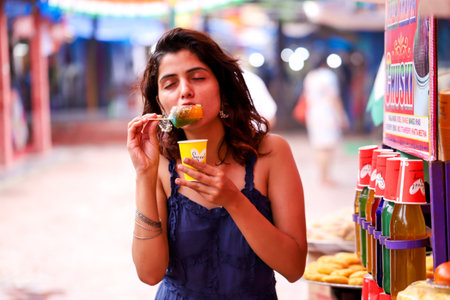 Young woman eating ice cream in a street food market.の写真素材
