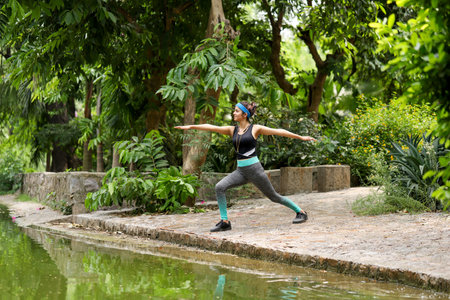 Beautiful asian woman doing yoga exercise in the park. Healthy lifestyle concept.の写真素材