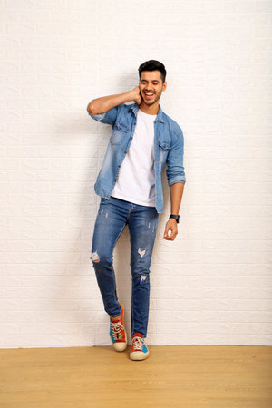 Young asian man wearing jeans shirt and sneakers on a white wall backgroundの写真素材