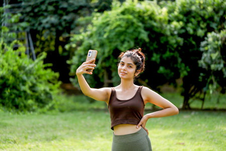 Portrait of young woman taking a selfie in the parkの写真素材