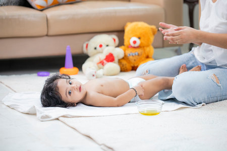 Asian mother playing with her baby in the living room at home.の写真素材