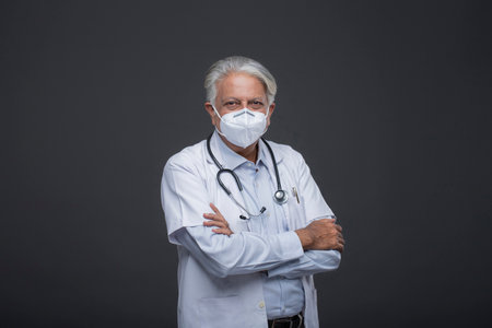 Portrait of senior doctor with stethoscope isolated on black backgroundの写真素材