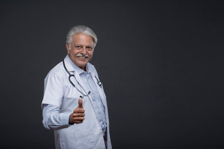 Portrait of senior doctor with stethoscope on grey background.の写真素材