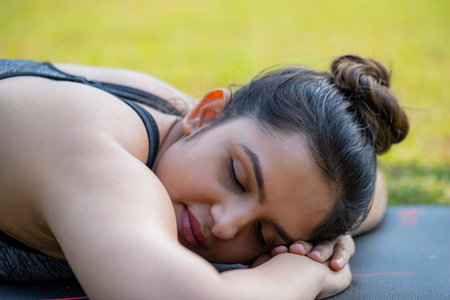 Portrait of a young woman doing stretching in the park.の写真素材