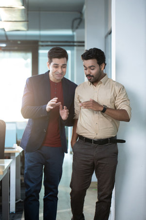 Portrait of two businessmen discussing while standing in office