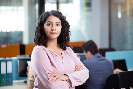 Portrait of confident businesswoman with arms crossed in meeting room at officeの写真素材