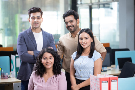 Portrait of smiling business people standing with arms crossed in creative officeの写真素材