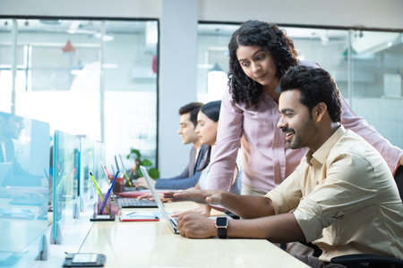 Portrait of business people working together at desk with computers in officeの写真素材