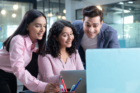 Group of happy business people working together in office. They are smiling and looking at camera.