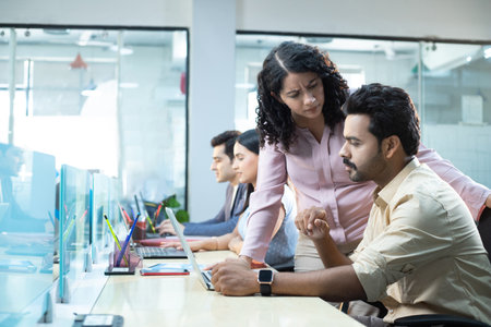 Portrait of business people using computers in office with colleagues in backgroundの写真素材