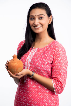 Smiling woman holding a piggy bank on white background.の写真素材