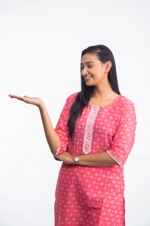 Smart beautiful woman showing empty space on open hand and looking at palm with smiling face
