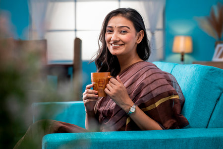 Portrait of a smiling young woman sitting on a sofaの写真素材