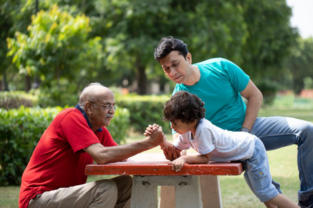 Grandfather and grandson playing together in the park. Asian family concept.