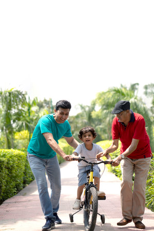 Three generation asian family spending time together and cycling in the park