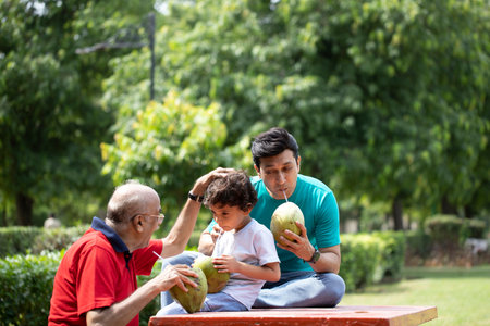 Asian family eating coconut in the garden. Asian grandfather and his grandson.