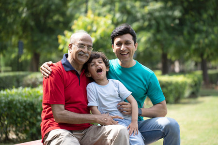 Portrait of happy multi-generation family sitting on bench in park