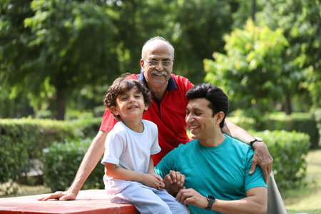 Portrait of happy senior man with his grandson and grandson in parkの写真素材