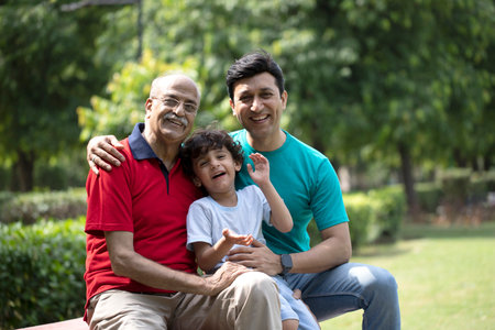 Portrait of three generations of asian family sitting in the parkの写真素材