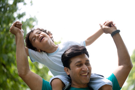 Father and son having fun in the park at the day time. Concept of friendly family.