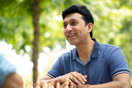 Portrait of young Indian man playing chess in the park outdoor.の写真素材