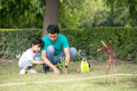 Father and son planting tree together in the garden. Concept of healthy family.の写真素材