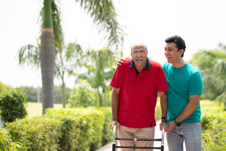 Asian senior man with walker and caregiver in the park.の写真素材