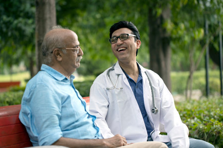Doctor and senior patient discussing something while sitting on bench in the park.の写真素材