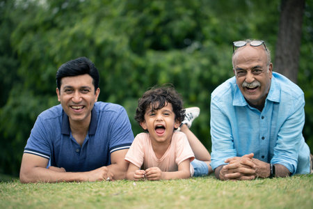 Portrait of happy multi-generation family lying on grass in park