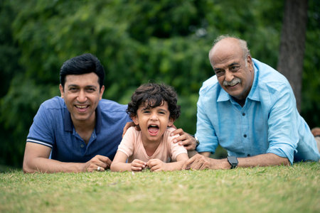 Portrait of Indian family lying on green grass in the park.の写真素材