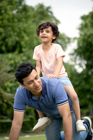 Father and son playing together in the park. Concept of friendly family.