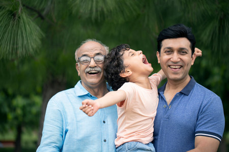 Portrait of Indian grandfather and his grandson having fun in the parkの写真素材