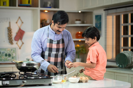 Father and son cooking together in the kitchen at home. Happy family concept.の写真素材