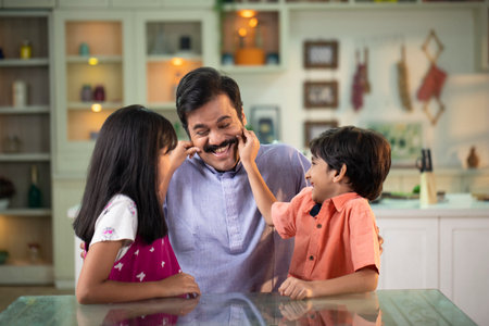 Happy family having fun in the kitchen at home. Father, mother and daughter are talking on the phone.の写真素材