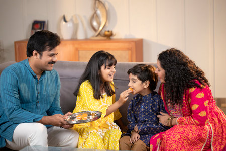 indian family eating food in the living room at home during the dayの写真素材