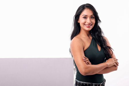 Portrait of a beautiful young woman holding a blank board on a white backgroundの写真素材