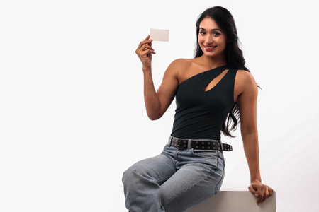 Attractive young woman holding a blank business card on white background.の写真素材