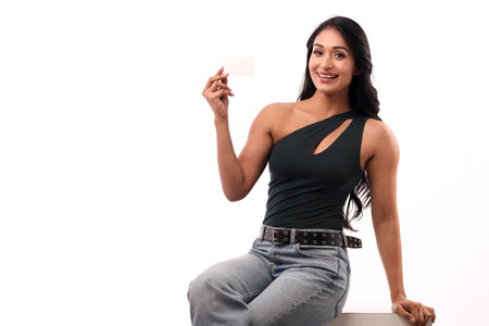 Young woman holding a blank business card, isolated on white background.の写真素材